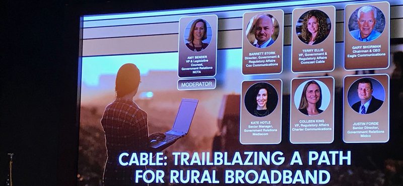 video display of people participating in a panel discussion on rural broadband
