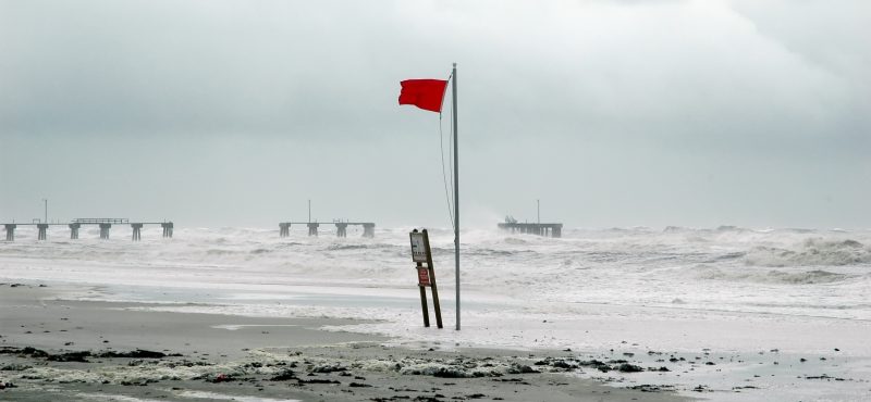 a flag on the shore waves wildly durring a hurricane