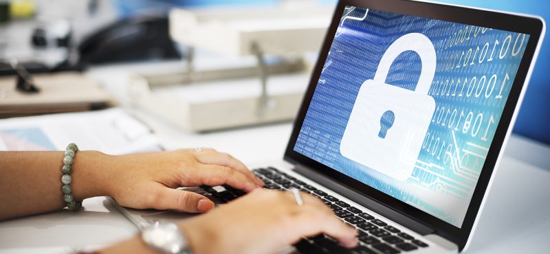 a person using a laptop with a padlock background image on the screen