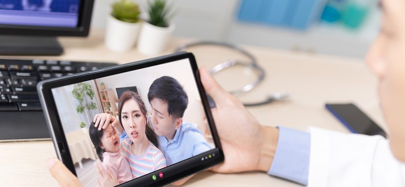 a doctor in a telemedicine appointment with a family